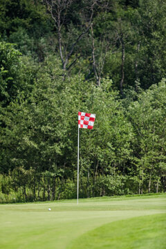 a red and white flag marks a hole on a golf course
