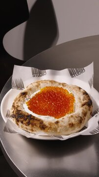 Fresh bakers prepare bread topped with caviar in a busy kitchen