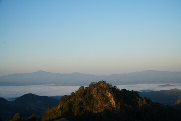 Mountain Range Under Clear Blue Sky with Soft Clouds