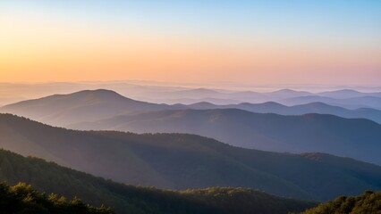 Serene mountain range at sunset with misty valleys and rolling hills