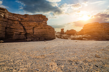 Desert sandy ground and spectacular yardang landform mountain natural landscape at sunset
