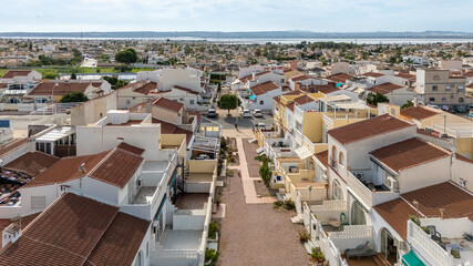 Elevated view of residential neighborhood with tiled rooftops and distant salt lake