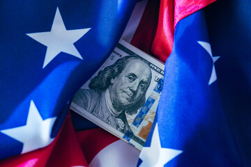 Money tucked between American flags represents patriotism and national pride during celebrations or significant events