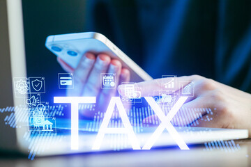 People managing taxes using mobile apps while working on laptops in a modern office setting