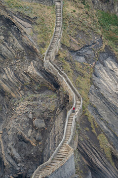 Endless zigzagging stone steps on a rocky mountain slope by the sea.