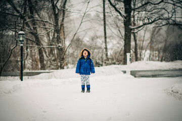 Young boy catching snowflakes during winter wonderland playtime