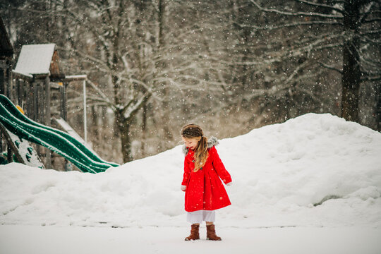 Little girl playing outside on snowy winter day