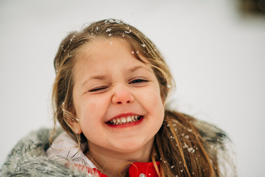 Close-up of smiling girl winking in snowy winter weather