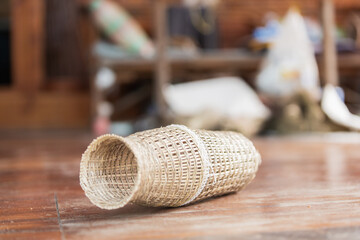 Handcrafted traditional Thai bamboo basket on rustic wooden floor