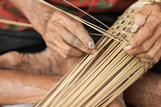 Elderly hands weaving traditional bamboo basket