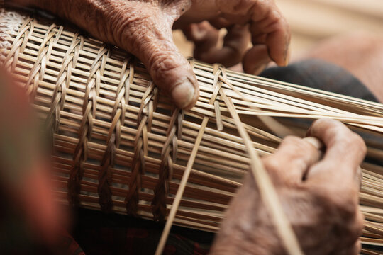 Experienced Thai artisan crafting traditional bamboo wicker basket