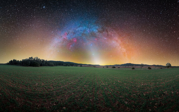 Milky Way with Constellations and Zodiacal Light Over Green Meadow