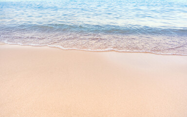 Soft blue ocean waves gently lapping onto a pristine tropical sandy beach