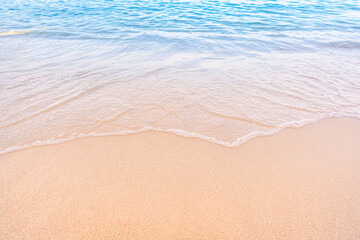 Soft blue ocean waves gently lapping onto a pristine tropical sandy beach