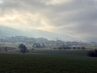 Idyllisches Dorf im Nebel an einem kalten Wintertag