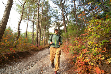 Naklejka premium Happy runner on the forest path in autumn