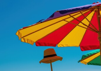 Obraz premium Brightly colored canvas parasol providing essential shade against the intense heat of a bright summer afternoon. Perfect seasonal escape ,sunshine ,summer ,travel