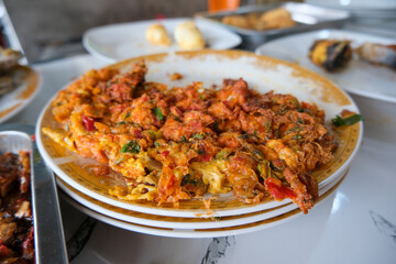 Fototapeta premium Telur Dadar (Indonesian omelette) served on a ceramic plate. The omelette is thick, crispy, heavily textured with green onions and red chilies, reflecting a common staple in Southeast Asian cuisine