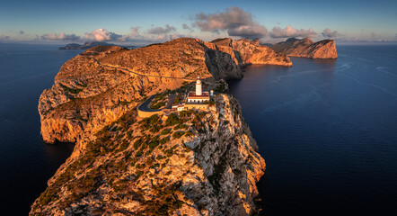 Mallorca, Spain - Aerial panoramic view of the Lighthouse at Cap de Formentor at sunrise with amazing cliffs of the Balearic islands and clouds and blue sky at background