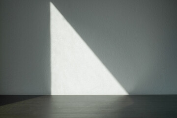 Empty white cement wall room and black table with shadow from window.