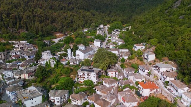 Aerial drone approach shot flying toward the whitewashed Church of Panagia, situated in the traditional stone village of Panagia on Thasos Island, Greece.