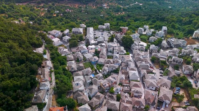 Birds eye aerial drone view directly over the traditional Greek village of Panagia, showing stone houses nestled on the forested slopes of Mount Ipsarion, Thasos Island, Greece.