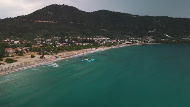 Aerial drone shot panning over the pristine golden sands and turquoise waters of Golden Beach Bay, Thasos Island, Greece.