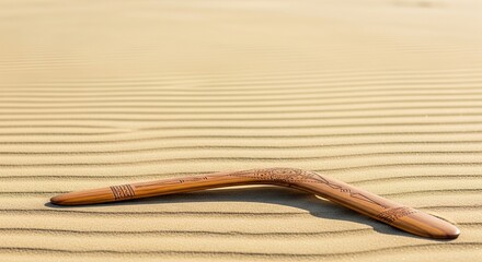 Traditional aboriginal boomerang resting on rippled sand dunes, symbolizing Australian indigenous culture and heritage concept for Australia Day celebration