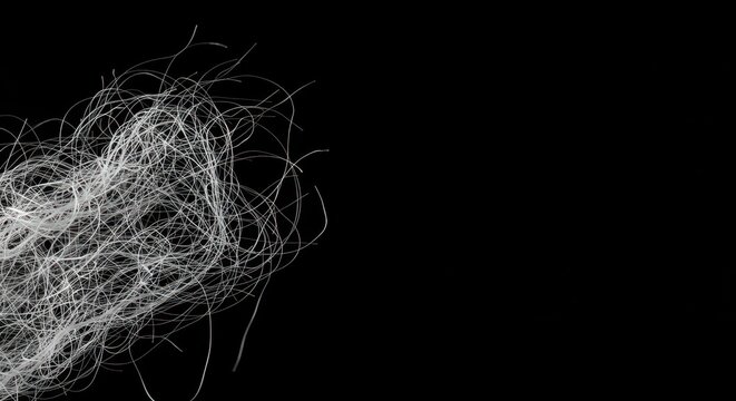 Extreme macro view of fine, tangled white textile fibres floating against a stark black background, emphasizing texture and structure ,fibre ,detail ,purity