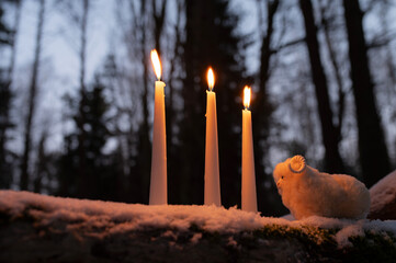 Wiccan altar for Imbolc holiday. Brigids cross of straw, candles, witch doll ram/sheep on snow. witchcraft, magic pagan ritual.