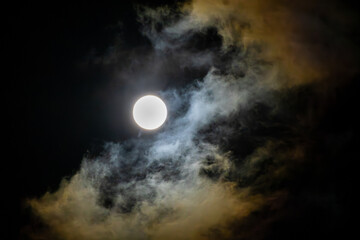 Full moon behind dramatic clouds