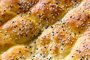 Close-up of a bakery product with sesame seeds. Fresh golden pie