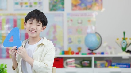 Smiling Boy Holding Foam Number Four in Classroom - Powered by Adobe