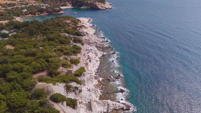 Aerial drone flight over the rugged coastal terrain and preserved Ancient Marble Quarries of Alyki Peninsula, Thasos, Greece.