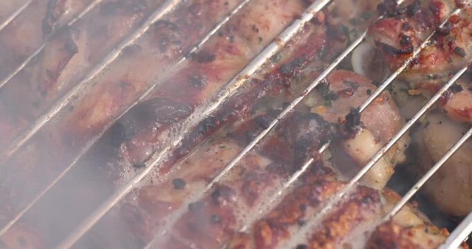 marinated meat with spices during cooking on the grill, roast pork on the grill with high heat and smoke