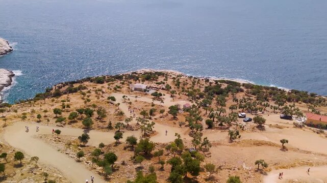 Aerial drone flight approaching the natural rock pool of Giola Lagoon, also known as Aphrodite's Tear, carved into the rugged coastline of Thasos Island, Greece.