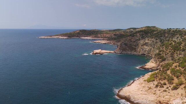 Panoramic aerial drone view of the rugged coastline near Astris and Giola Lagoon, Thasos Island, Greece, highlighted by the turquoise Aegean Sea on a bright summer day.