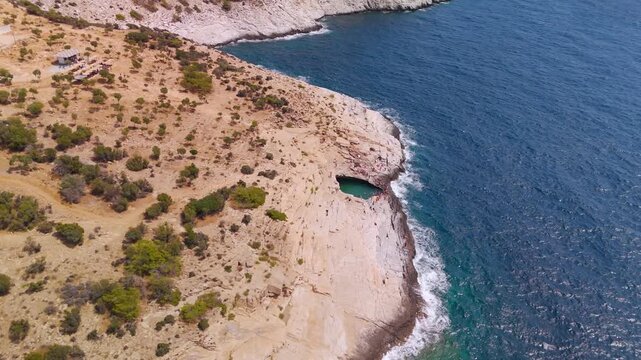 Circling Aerial Drone Shot Over Giola Lagoon, the Natural Rock Pool Known as Aphrodite's Tear, Carved into the Thasos Island Coastline, Greece.
