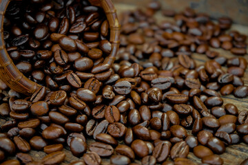  close-up  of a pile of coffee beans in a basket that has spilled and spread on the floor. Selective focus