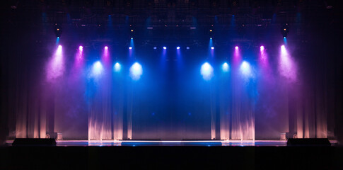 An empty stage of the theater, lit by spotlights and smoke before the performance