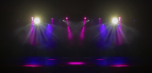 An empty stage of the theater, lit by spotlights and smoke before the performance
