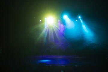 An empty stage of the theater, lit by spotlights and smoke before the performance
