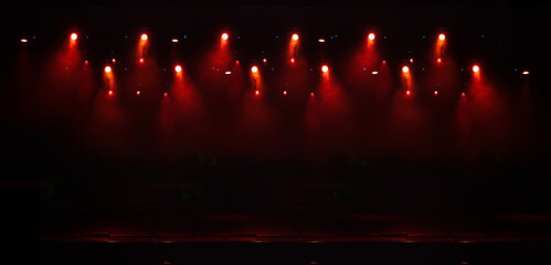 An empty stage of the theater, lit by spotlights and smoke before the performance