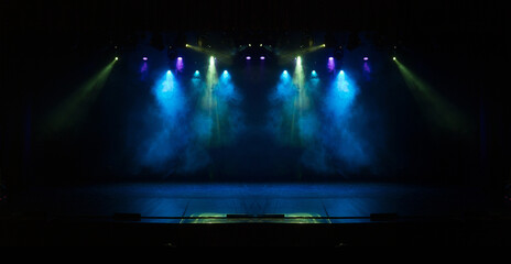 An empty stage of the theater, lit by spotlights and smoke before the performance