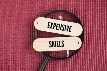Magnifying glass and wood with the word expensive skills. specialized, in-demand capabilities that directly generate significant income or business value.