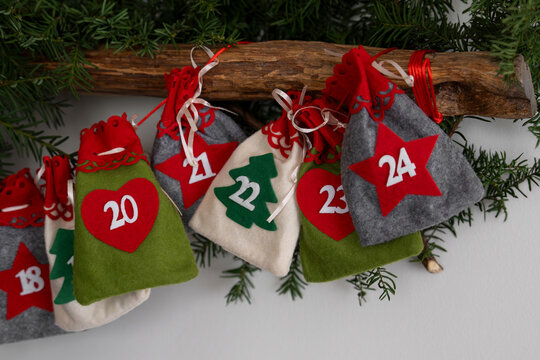 Advent calendar with colorful felt bags on Christmas tree branches