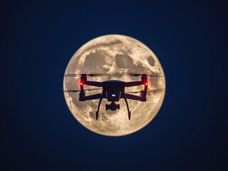 Drone flying in front of full moon
