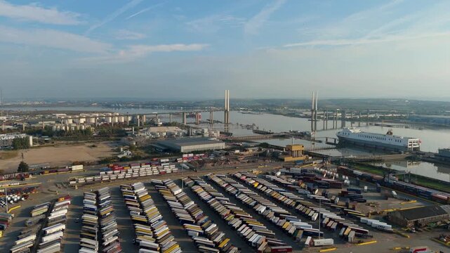 Aerial drone view of industrial port infrastructure along River Thames with Queen Elizabeth Bridge and Dartford tunnel late evening sunset, London UK.