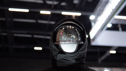 Visor reflection closeup capturing exhibition lights and ceiling architecture with glossy curvature and layered reflections on transparent shield, moody contrast and studio bokeh