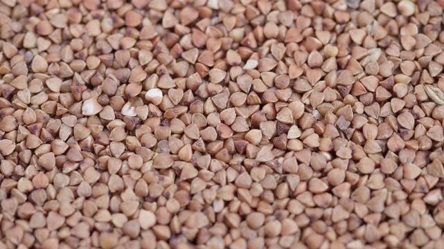 Buckwheat kernels closeup, Close view of organic buckwheat kernels with fine grain, Macro photograph showcasing raw buckwheat with detailed textures and warm beige hues